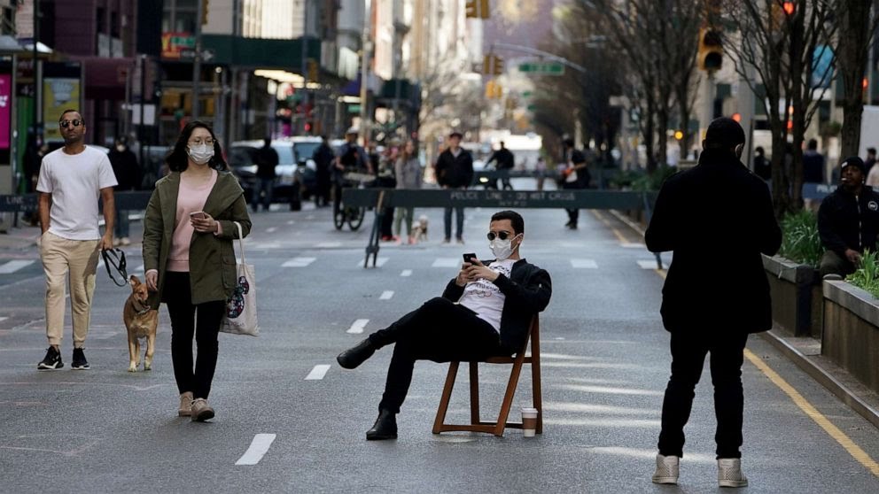 FILE PHOTO: A man sits on a chair as people walk on Park Avenue that was closed to vehicular traffic during the outbreak of coronavirus disease (COVID-19), in the Manhattan borough of New York City, New York, U.S., March 27, 2020. Carlo Allegri/Reuters